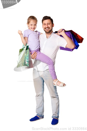 Image of Happy father and daughter with shopping bags standing at studio 