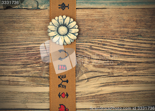 Image of vintage tape with embroidered ornaments and old flower button