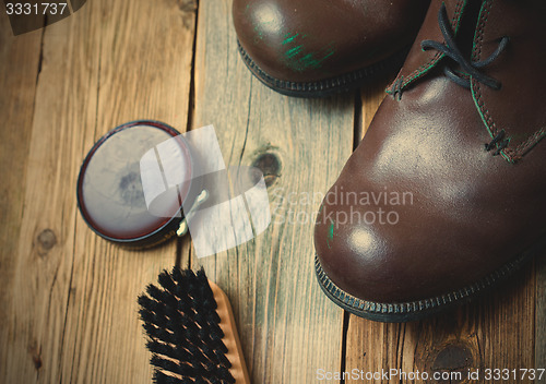 Image of brown boots, shoe polish and shoe brush