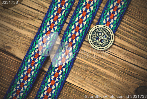 Image of vintage ribbon with embroidered ornament and old classic button