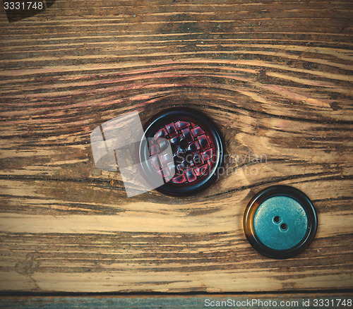 Image of two vintage buttons on aged wood surface