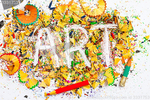 Image of art word on the background of colored pencil shavings