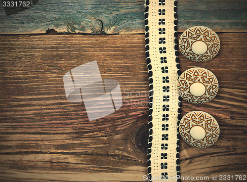 Image of Vintage tape with embroidered pattern and ancient three buttons
