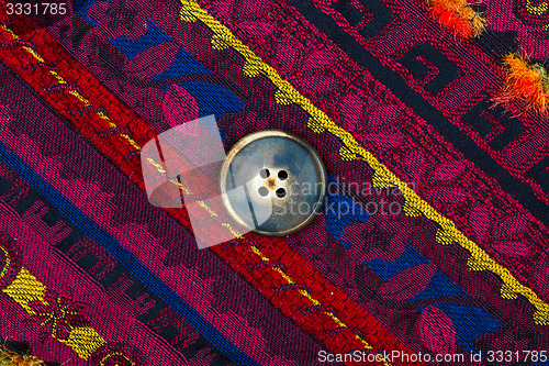 Image of vintage tape with embroidered ornaments and old brown buttons