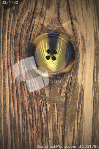 Image of vintage button on the aged textured boards