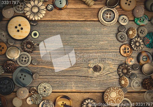 Image of placer of vintage buttons with copy space on textured old boards