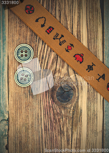 Image of vintage band with embroidered ornaments and old button