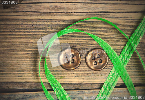 Image of still life with old green tape and two vintage buttons