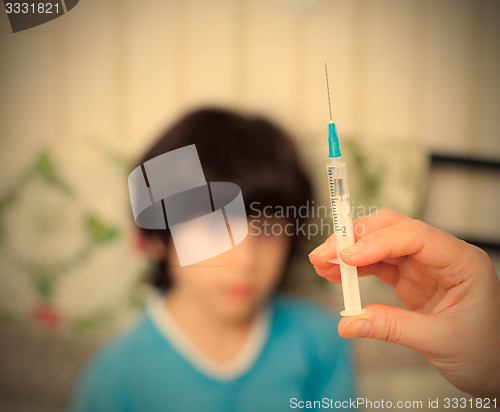 Image of Doctor hand with syringe and boy