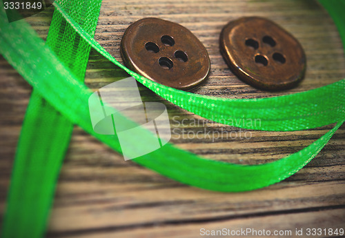 Image of still life with old green tape and two vintage buttons