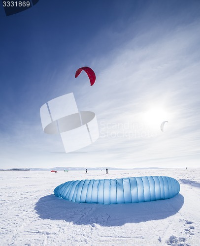 Image of Kiteboarder with blue kite on the snow