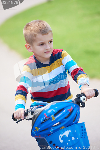 Image of happy boy learning to ride his first bike