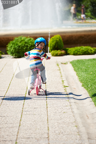 Image of happy boy learning to ride his first bike