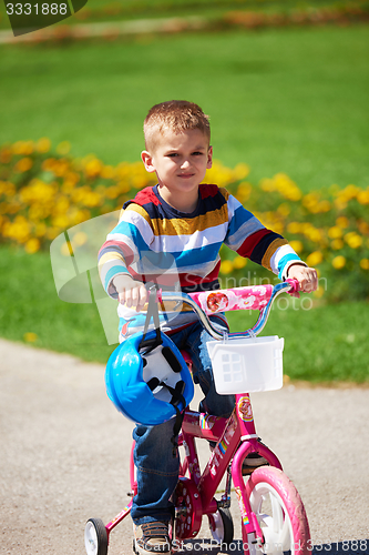 Image of happy boy learning to ride his first bike