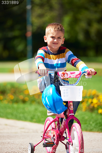 Image of happy boy learning to ride his first bike