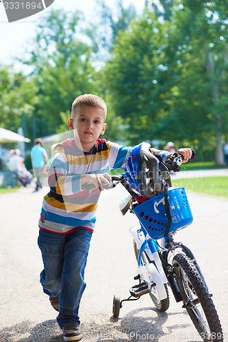 Image of happy boy learning to ride his first bike