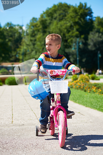 Image of happy boy learning to ride his first bike