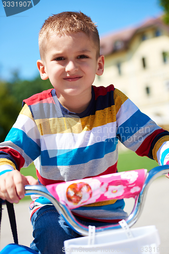 Image of happy boy learning to ride his first bike