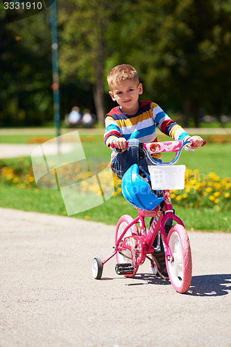 Image of happy boy learning to ride his first bike