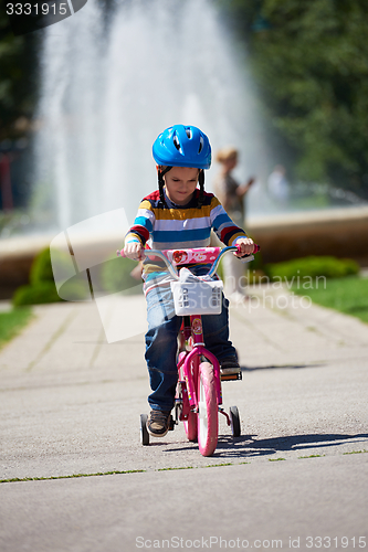 Image of happy boy learning to ride his first bike
