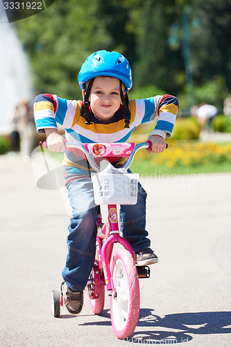 Image of happy boy learning to ride his first bike