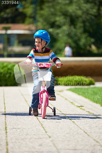 Image of happy boy learning to ride his first bike