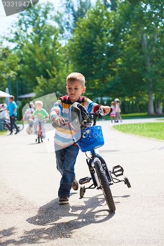 Image of happy boy learning to ride his first bike