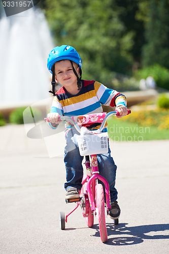 Image of happy boy learning to ride his first bike