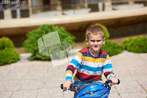 Image of happy boy learning to ride his first bike