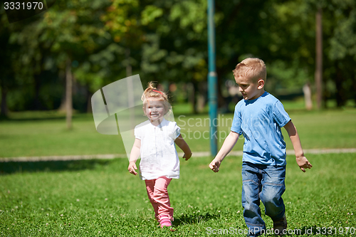 Image of Boy and girl have fun and running in park