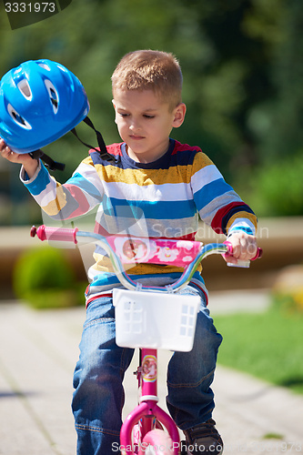 Image of happy boy learning to ride his first bike