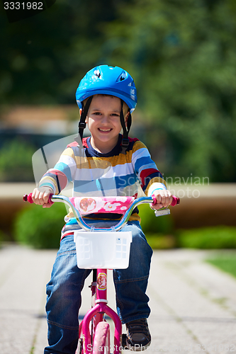 Image of happy boy learning to ride his first bike