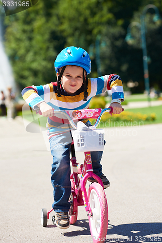 Image of happy boy learning to ride his first bike