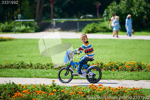 Image of happy boy learning to ride his first bike