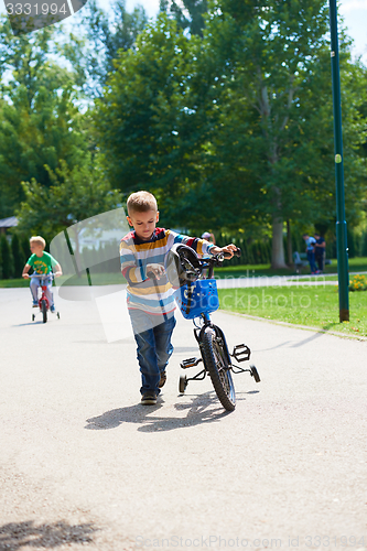 Image of happy boy learning to ride his first bike