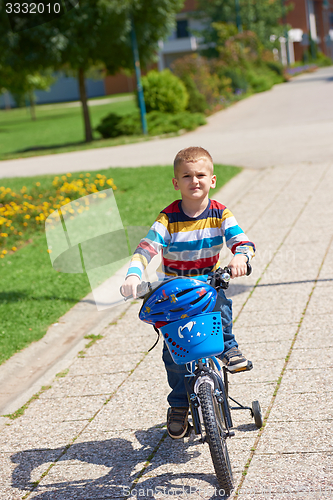 Image of happy boy learning to ride his first bike
