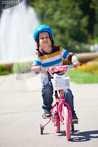 Image of happy boy learning to ride his first bike