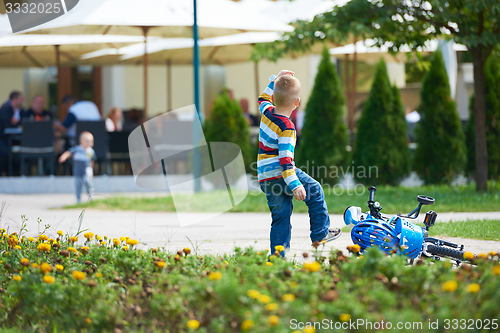 Image of happy boy learning to ride his first bike