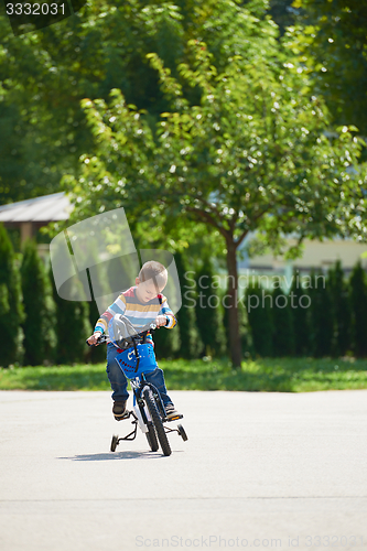 Image of happy boy learning to ride his first bike