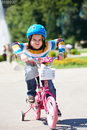 Image of happy boy learning to ride his first bike