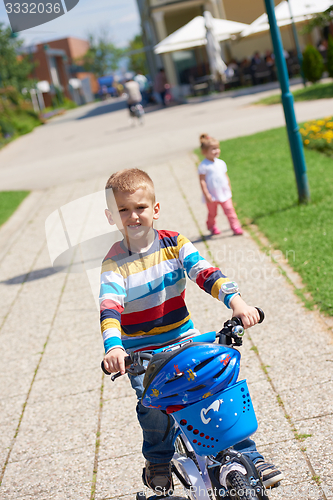 Image of happy boy learning to ride his first bike