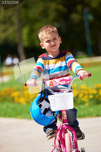 Image of happy boy learning to ride his first bike