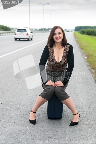 Image of Attractive woman sits on staircase near road