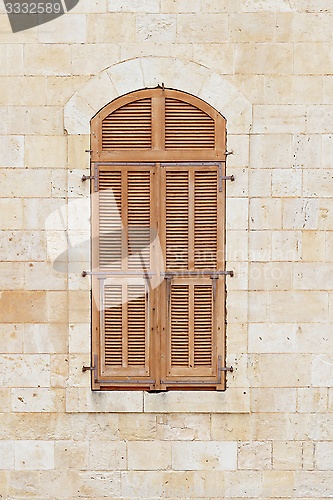Image of Closed window of the old building covered by wooden blinds