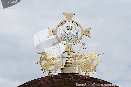 Image of Cross on Orthodox church with Mother Mary and two angels on cloudy sky background