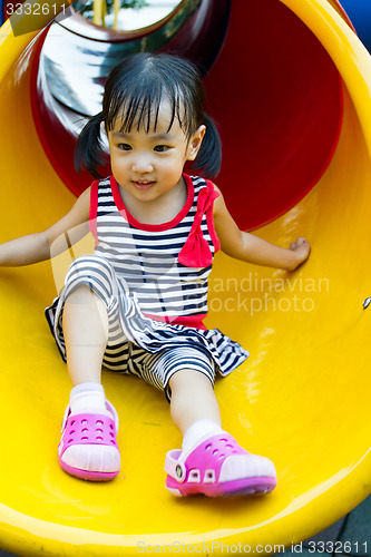 Image of Asian kid sliding on Playground