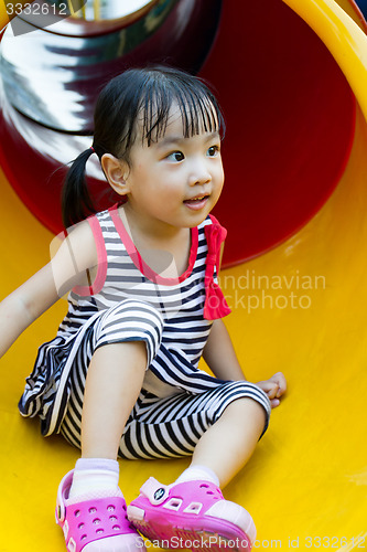 Image of Asian kid sliding on Playground