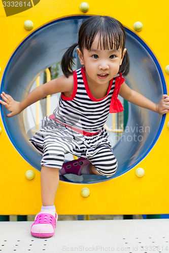 Image of Asian Kid Crawling on Playground Tube