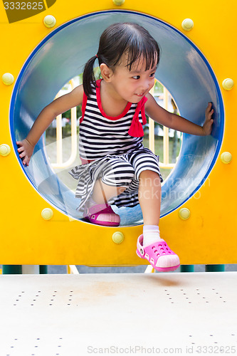 Image of Asian Kid Crawling on Playground Tube