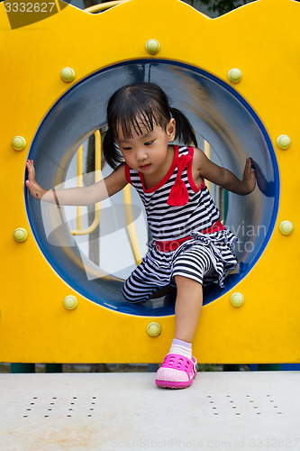 Image of Asian Kid Crawling on Playground Tube